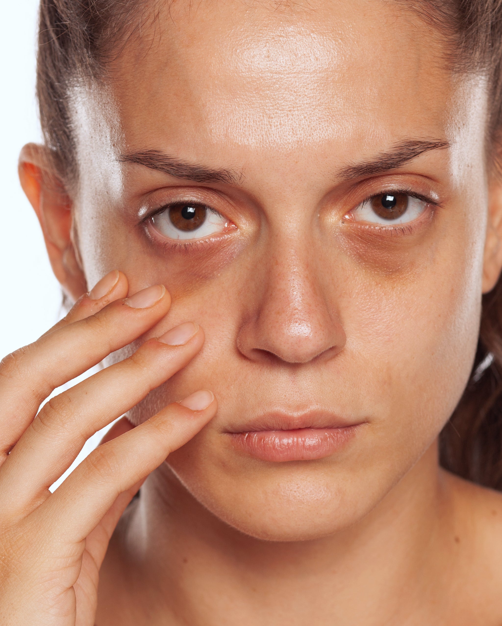 Femme touchant la zone des cernes sous les yeux